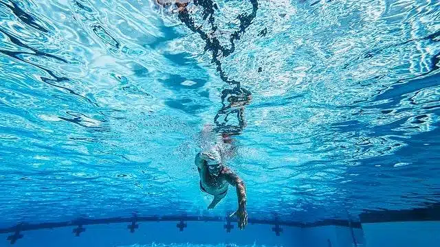 osoba pływająca w basenie z chlorem